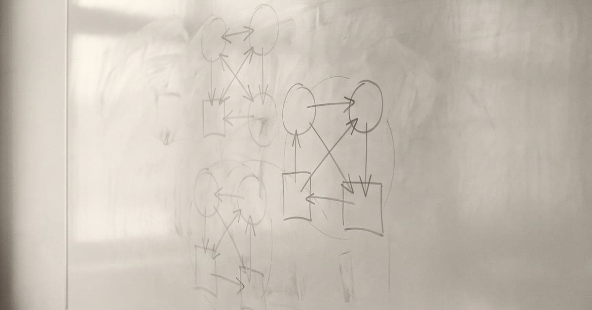 A wall-mounted writing surface carrying three overlapping diagrams, two of them partly erased