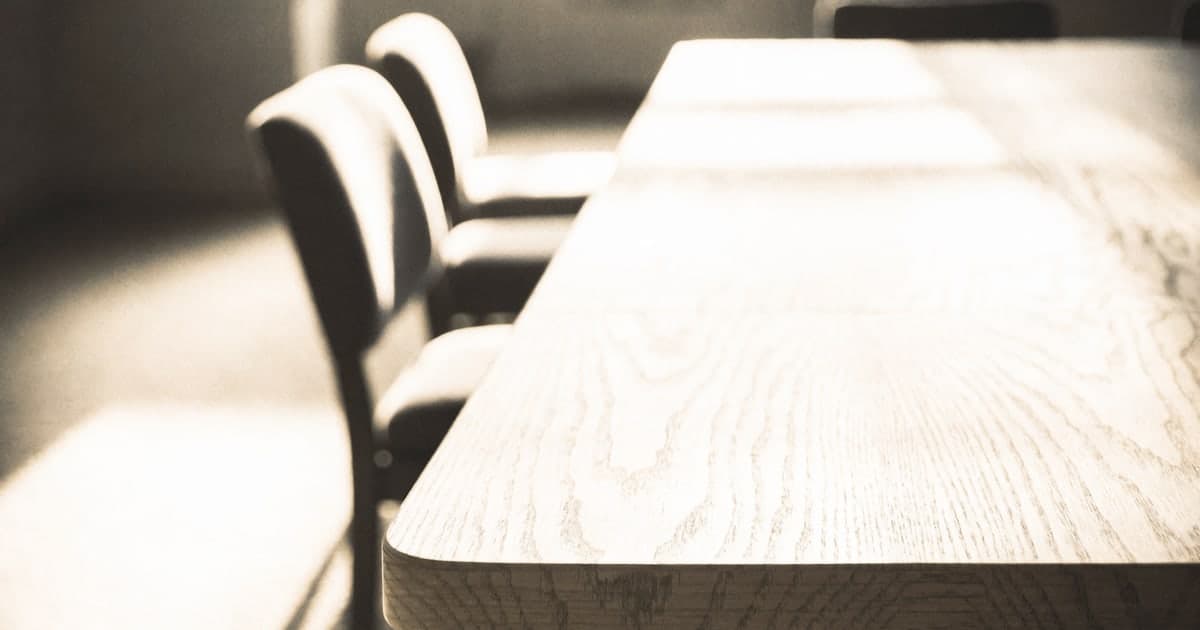 An empty boardroom table a few minutes after a meeting has ended